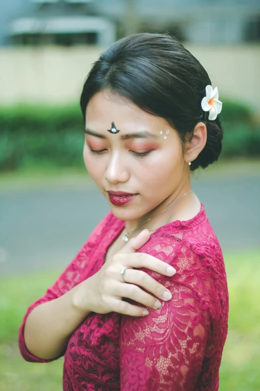 a woman wearing a pink shirt is looking down at her hands