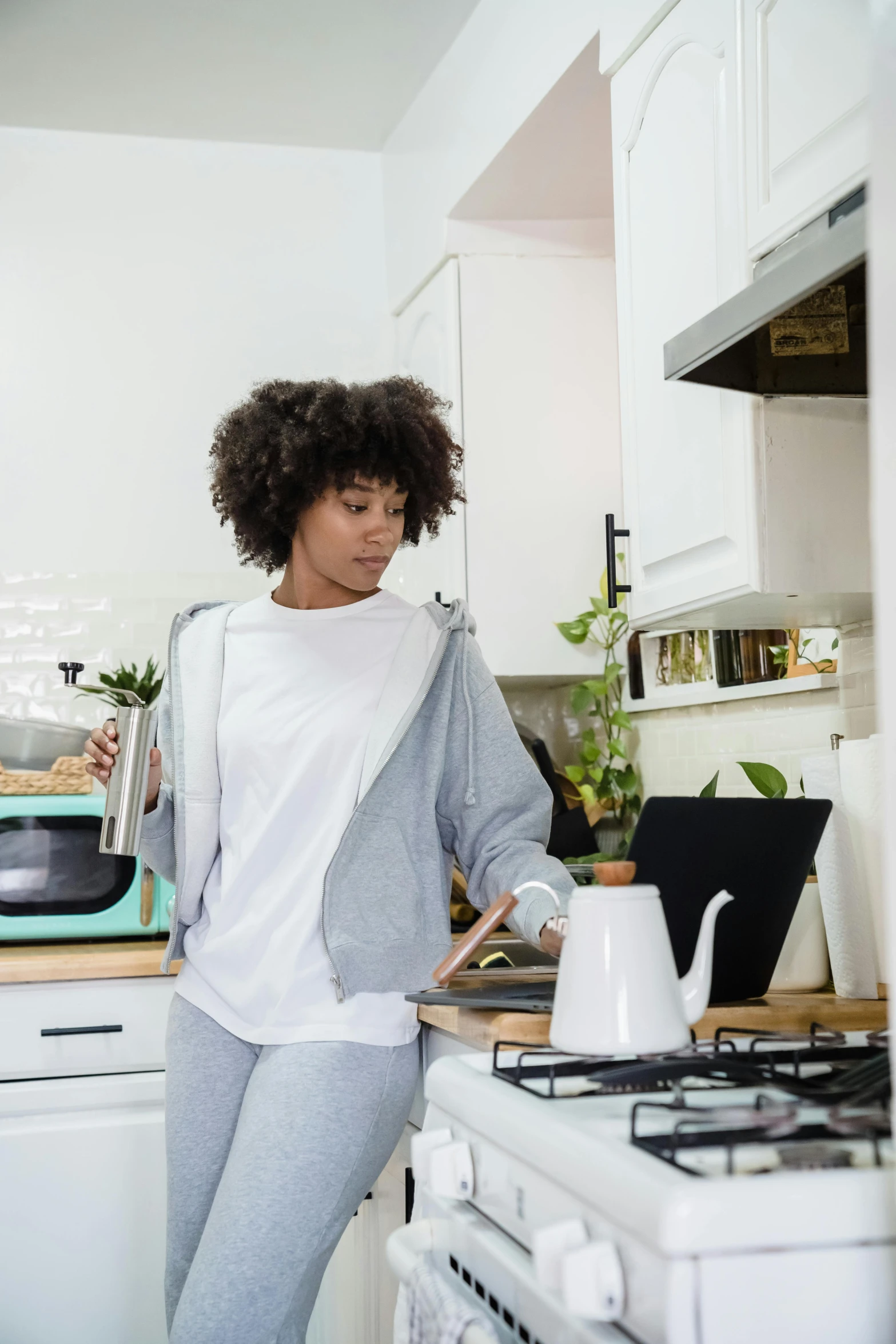a black woman leaning on the counter in a kitchen