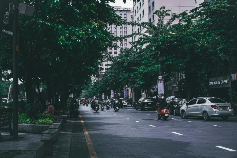 motorcycles on the street and people walking down the sidewalk