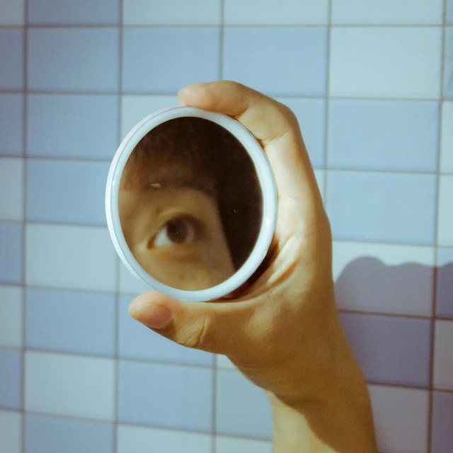 a person holding up a small white cup