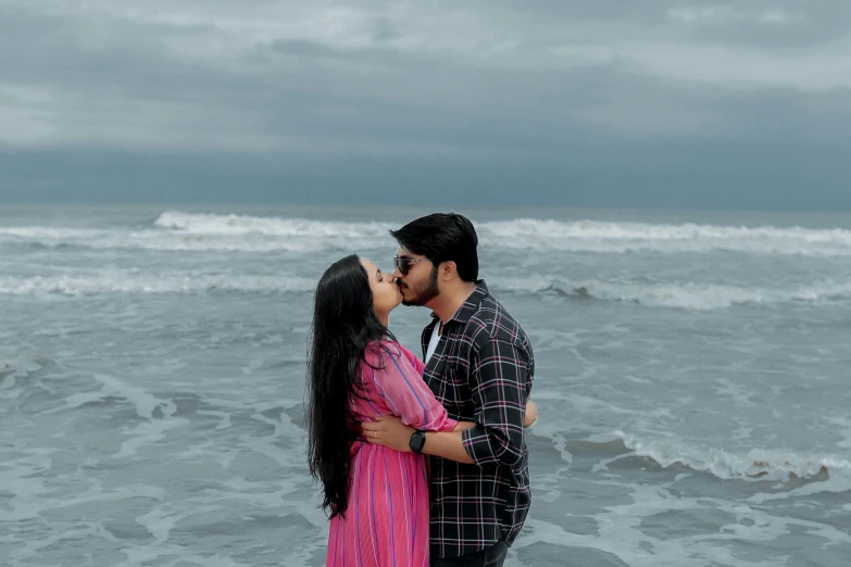 two people standing together on the beach