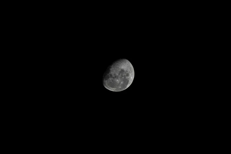 the moon is shown through the dark black sky