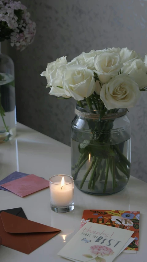 a vase filled with flowers and white candles on a table