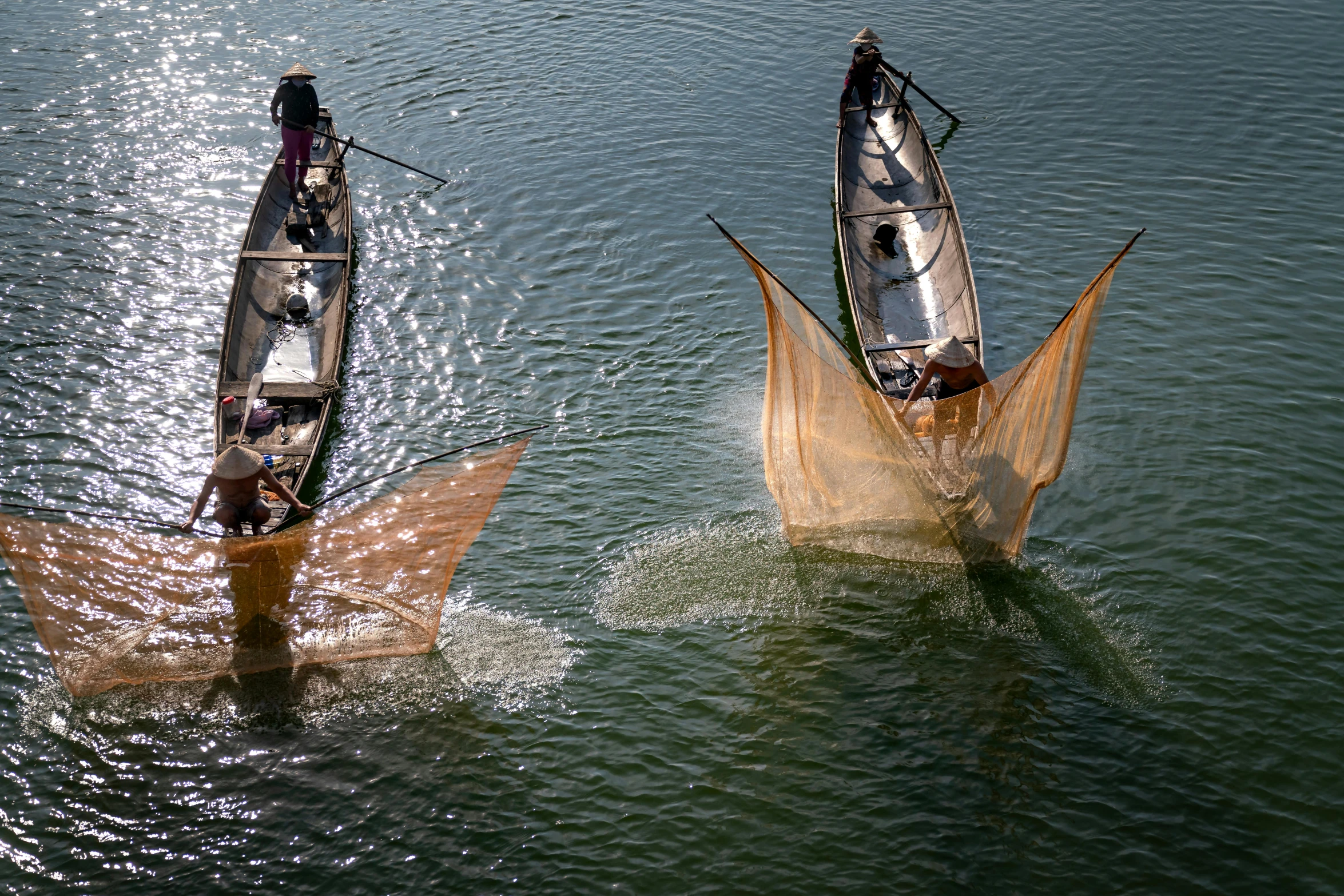 two long tailed boats with oars, one of which is tied to a boat