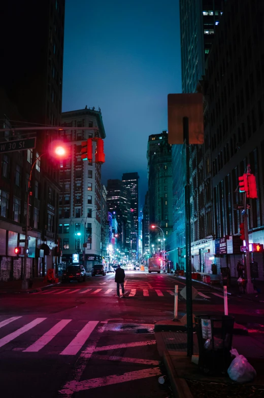 night scene of city street with pedestrian and traffic lights