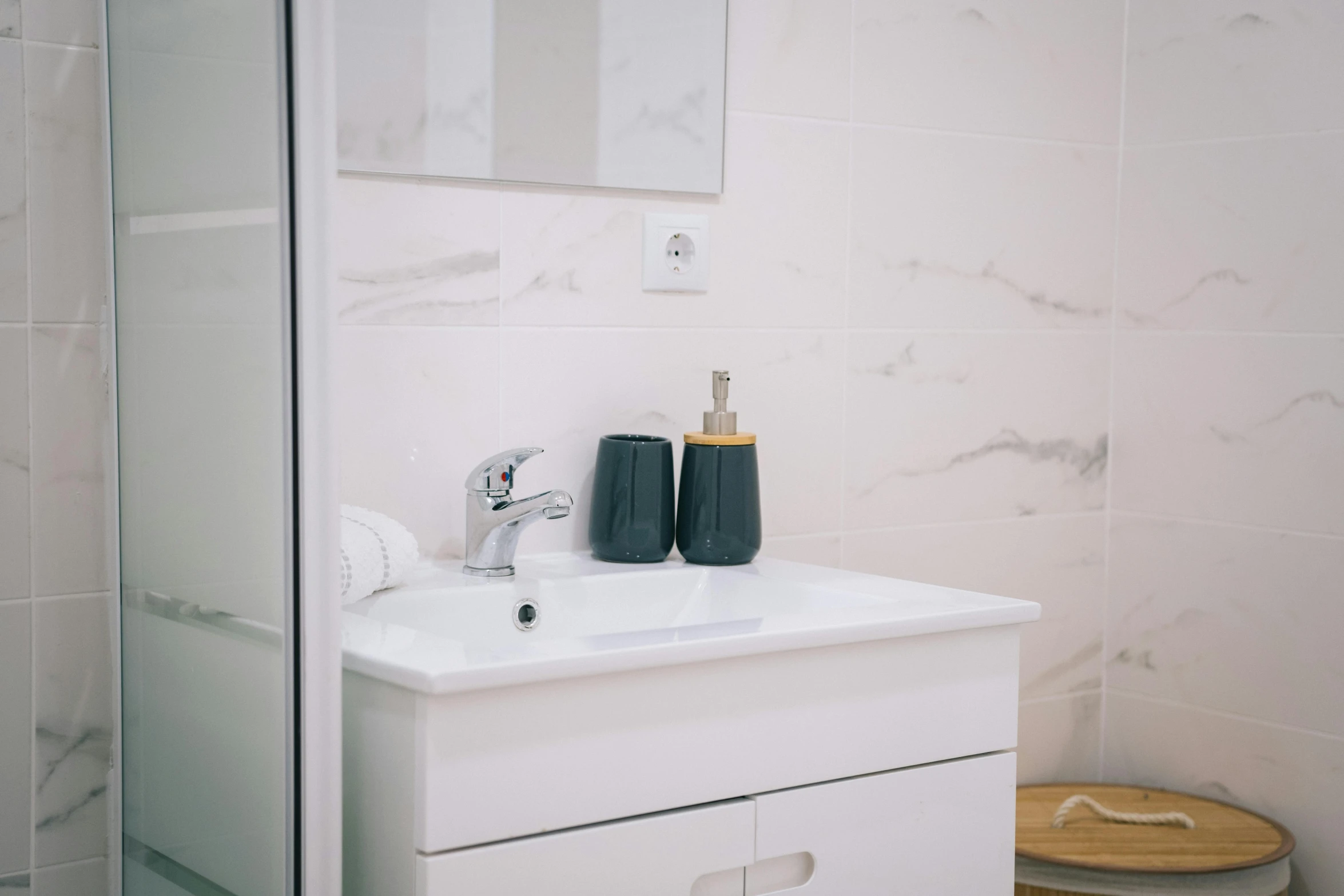 the bathroom sink has two black cups on it