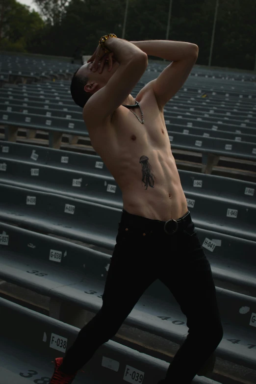 a shirtless man walking on a stadium bleachers