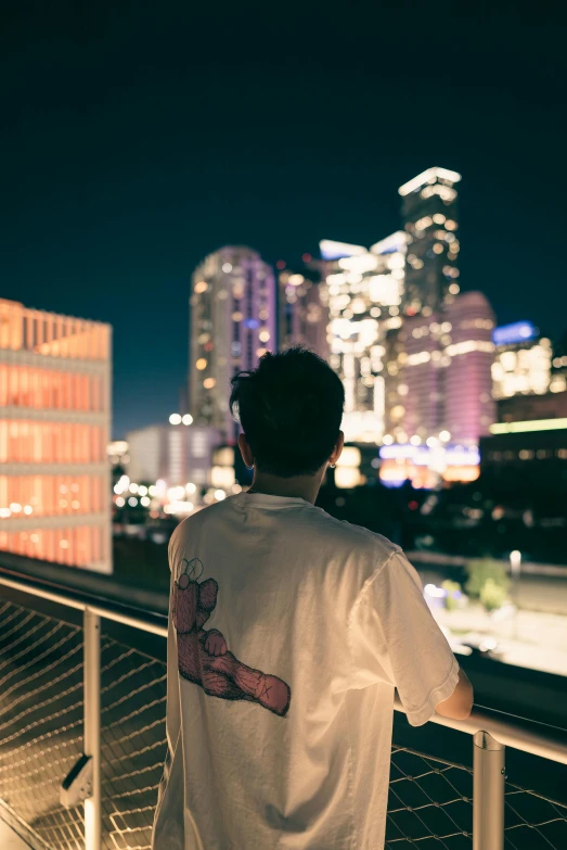 a man looks out over the city at night