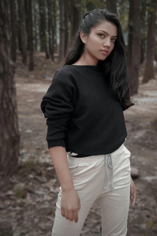 a woman with long hair posing in the woods