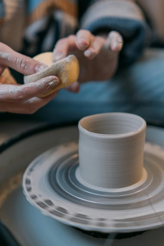 someone is making soing with clay on a wheel