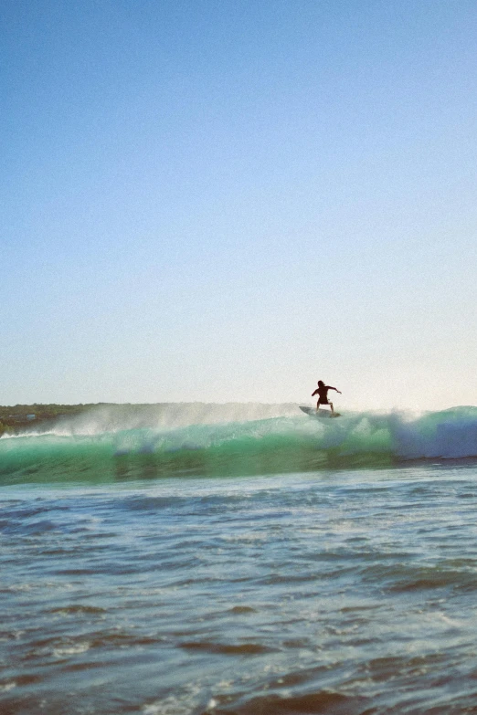 a man is surfing over waves at the beach