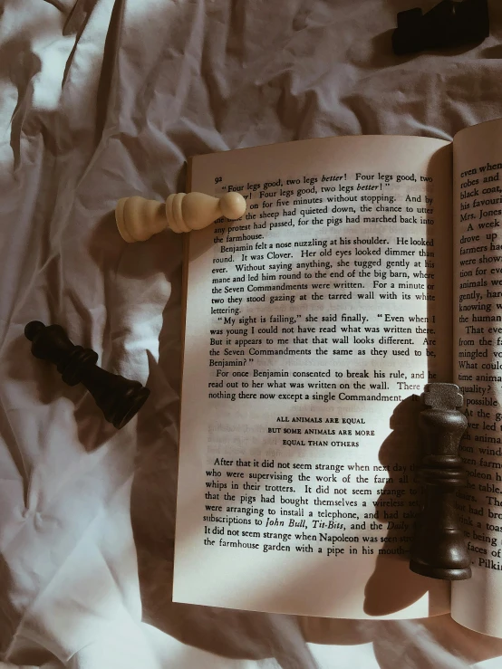 a book on top of a bed next to a bell