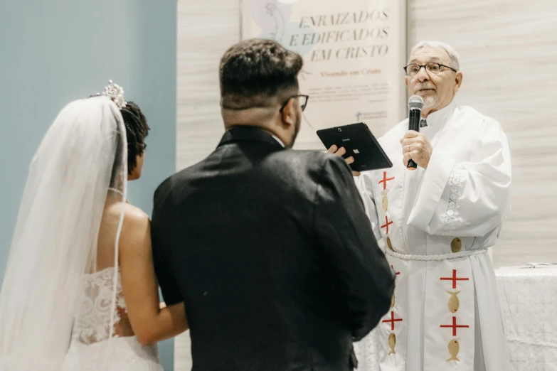 the priest is showing an elderly couple soing