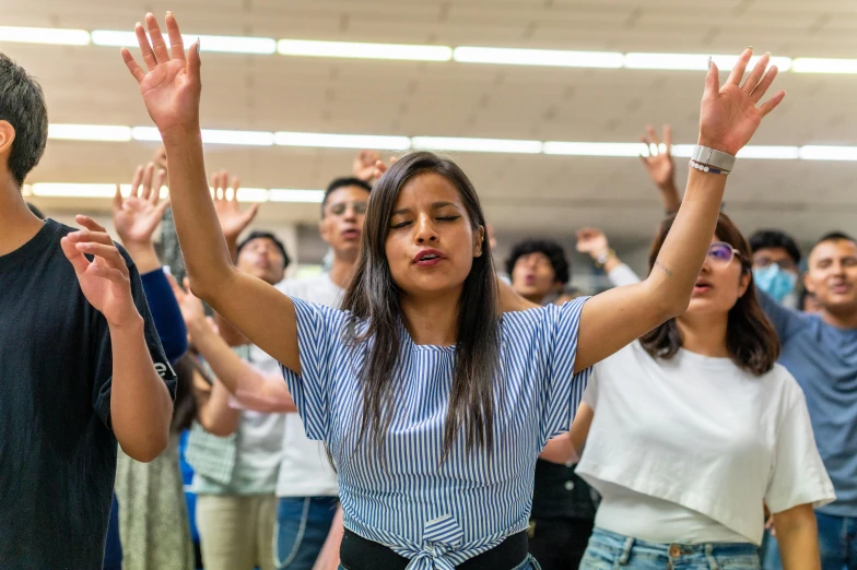 a group of people, with hands up, are clapping