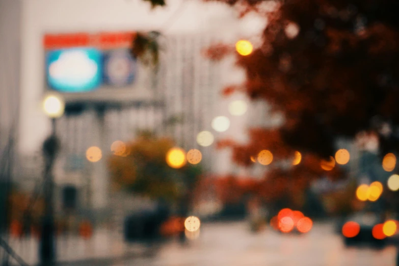 blurry image of a rainy street with cars and buildings