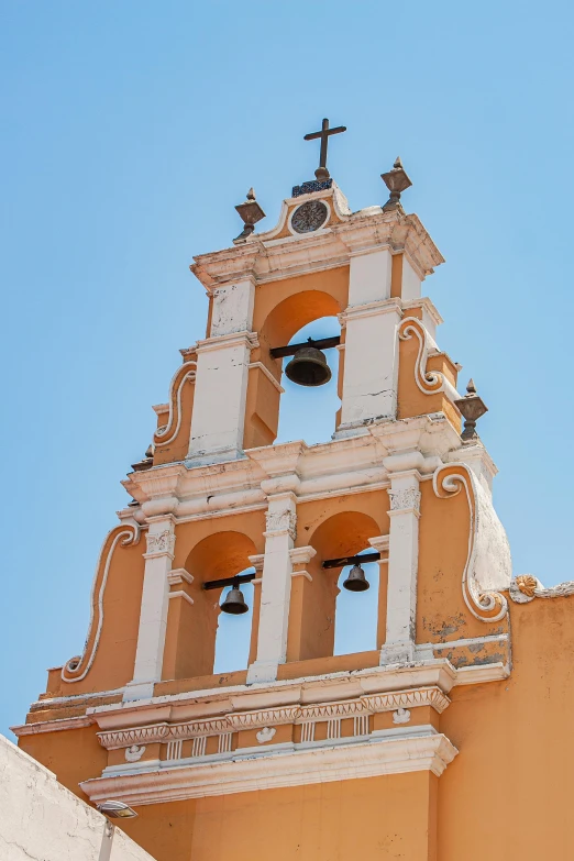 two bell towers with bells and cross on them