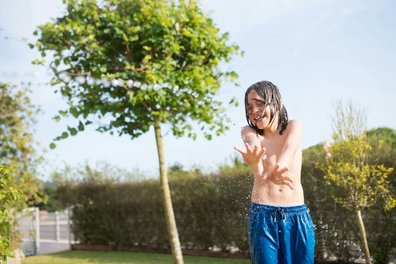 a boy in swimming trunks using a cell phone