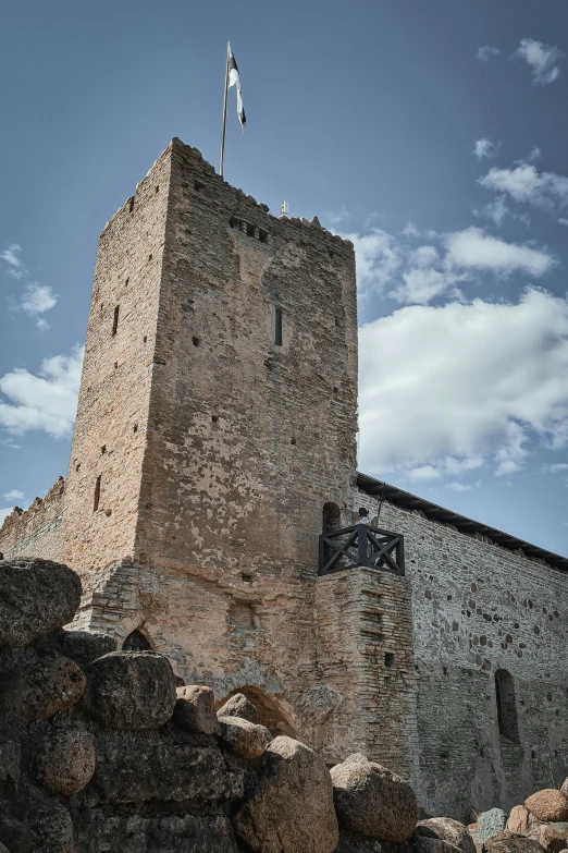 a tall stone building is surrounded by rocks