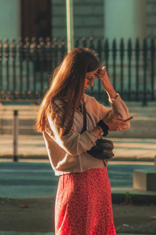 a woman with long red hair is looking at her cellphone