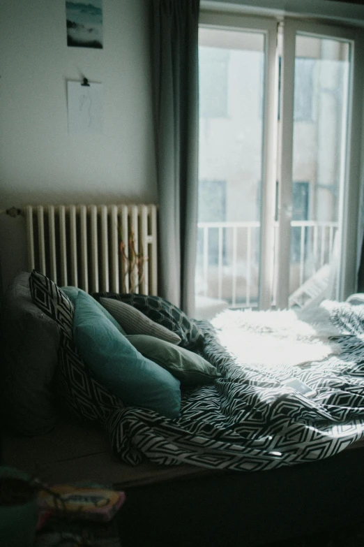 a large window sitting above a bed near a wall