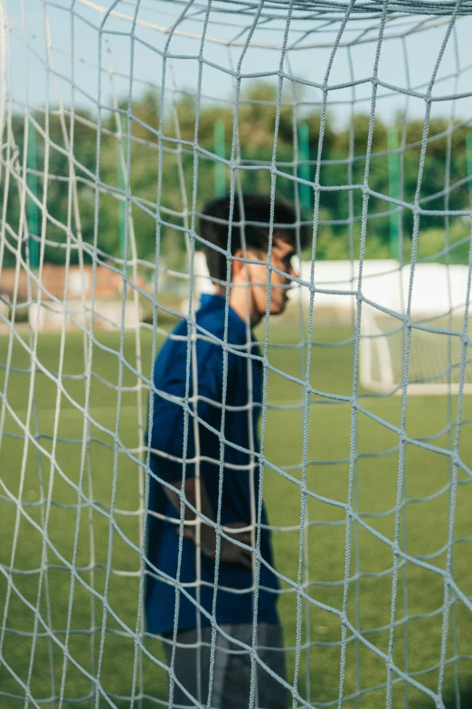 a man is walking towards the soccer net