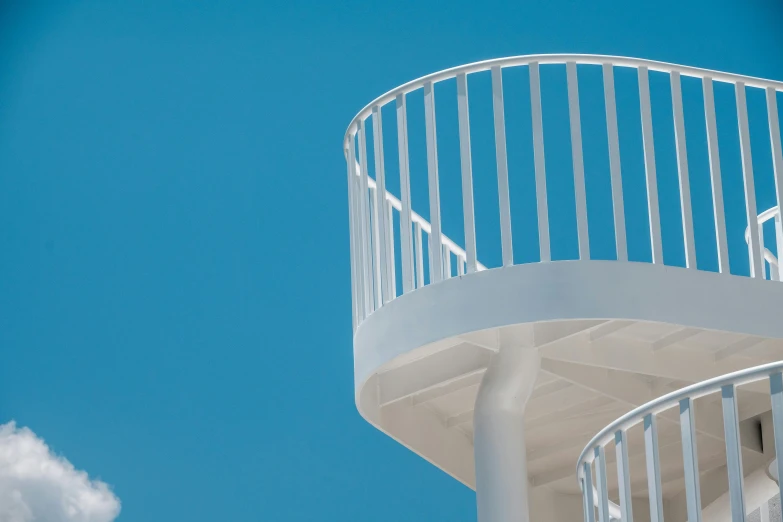 a spiral staircase with white metal railing and balustering