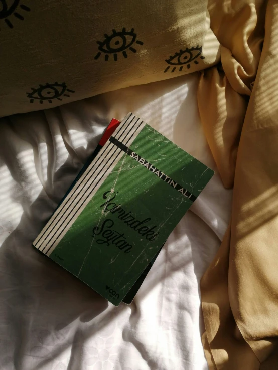 a book laying on top of a bed under a blanket