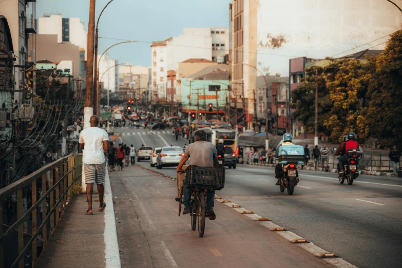 a couple of people on bikes riding down a road