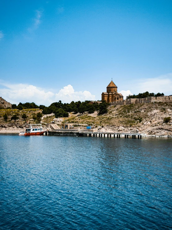 several boats in water near a large cliff