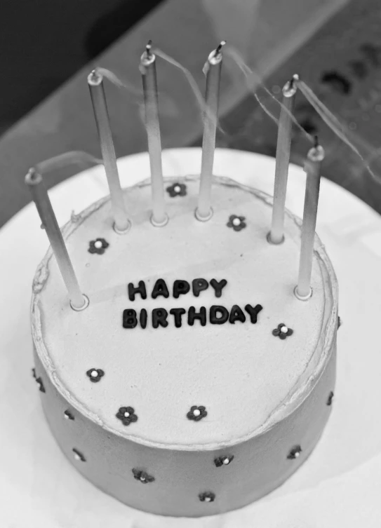 an old, white frosted cake with five candles that reads happy birthday