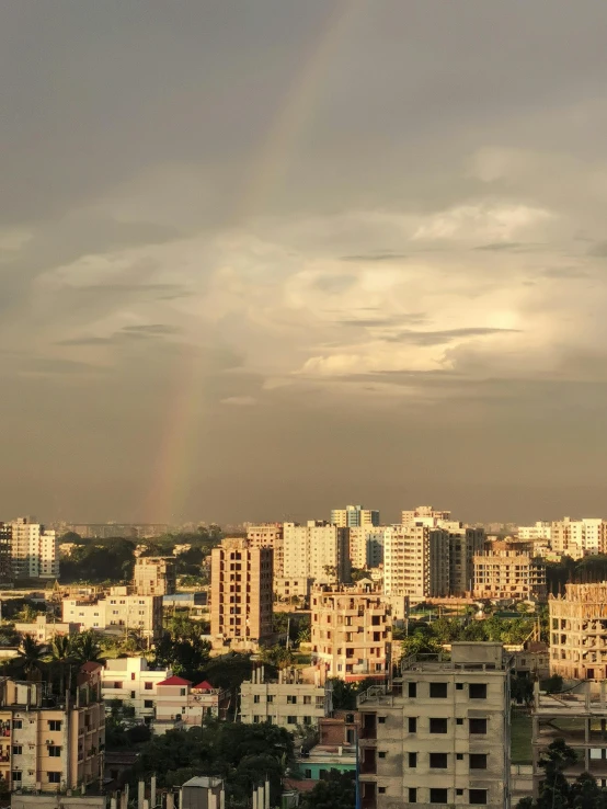 a rainbow is shining above a city