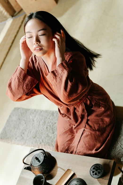 a woman sitting on the floor with her earphones over her ears