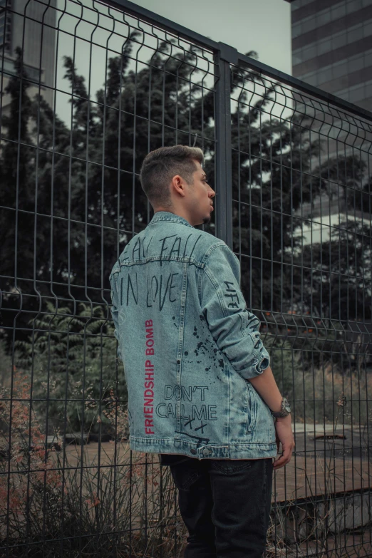 the man wearing a jean jacket has written on it