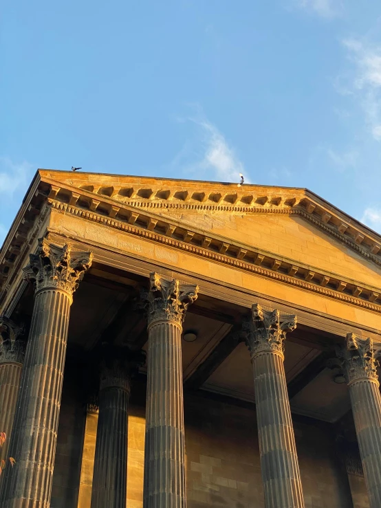 large columns surrounding a building under a blue sky