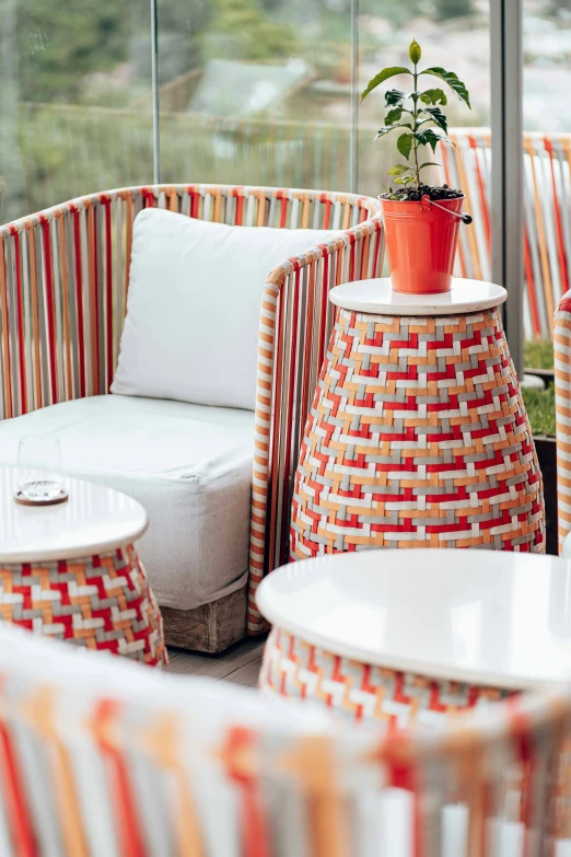 round seating area with striped seats, large windows and table with plant in it