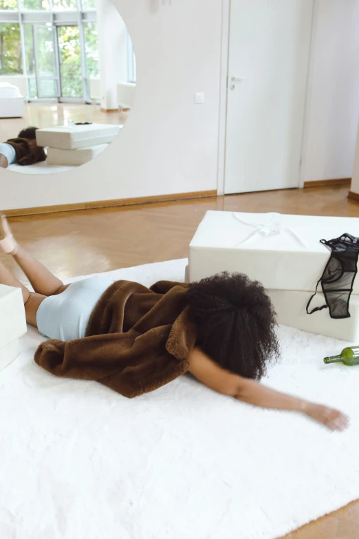 woman lying on white towel in living room next to mirror