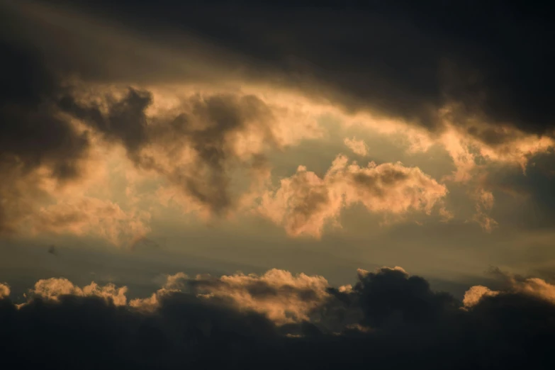 the plane is flying under a cloudy sky