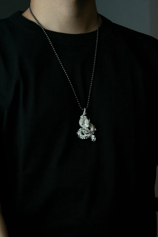 the man is wearing a necklace with a skull pendant