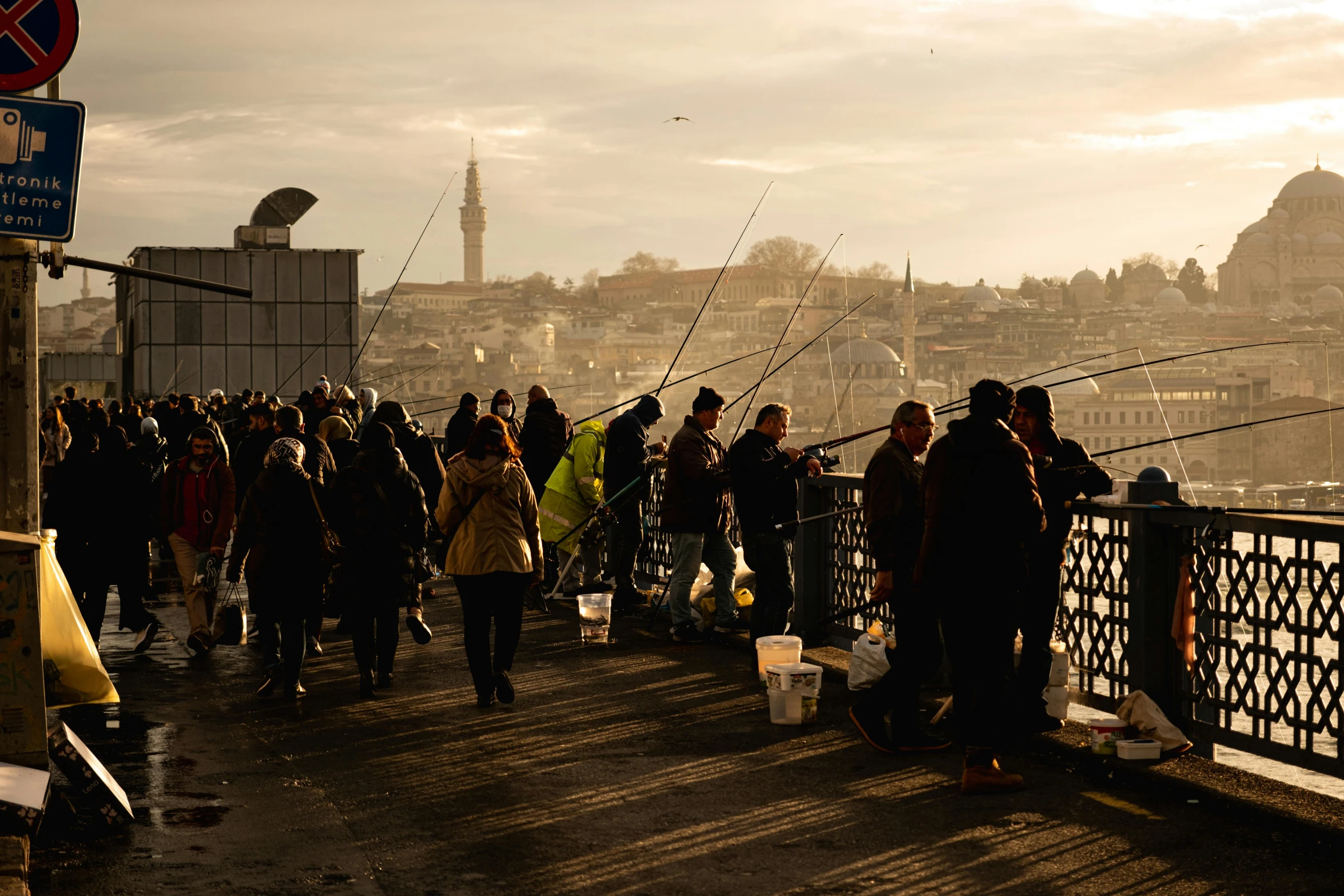 people standing on the edge of a bridge over looking a city