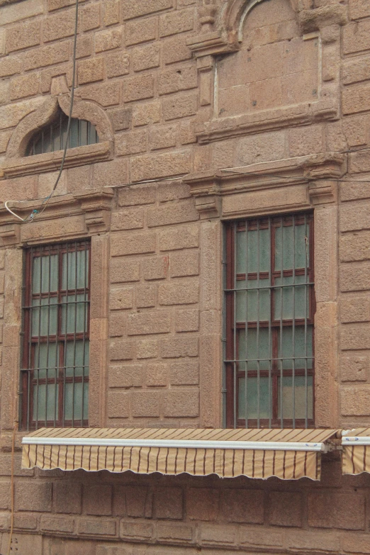 an old brick building with two windows on each side