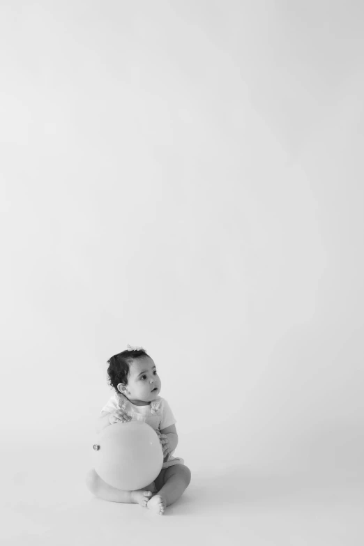 an infant sits in front of the camera wearing earbuds