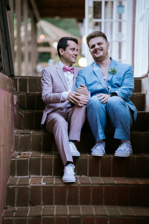 two men sitting on steps with ties and suits