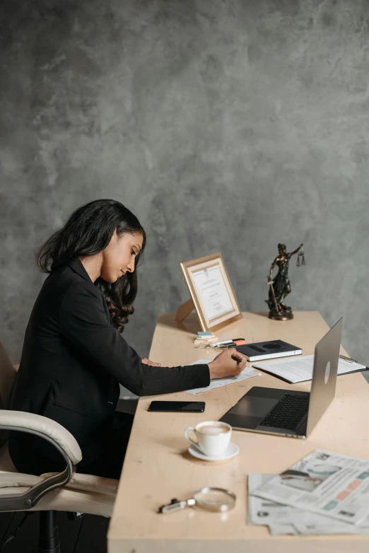 woman sitting at the desk in front of a laptop