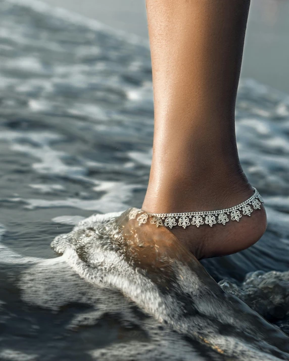 the bottom of a woman's foot in shallow water