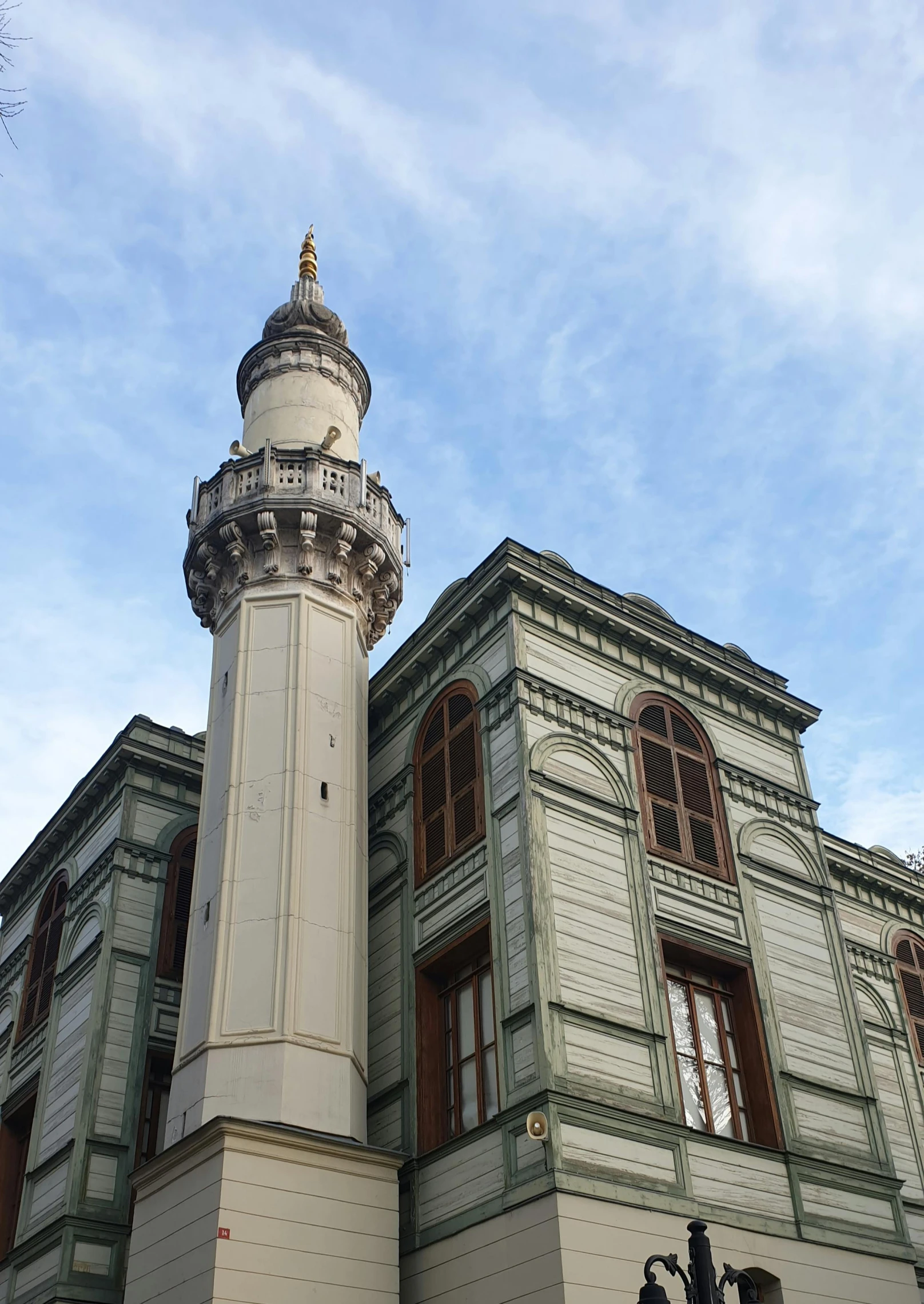 the tall tower of the building has a large clock on it's side