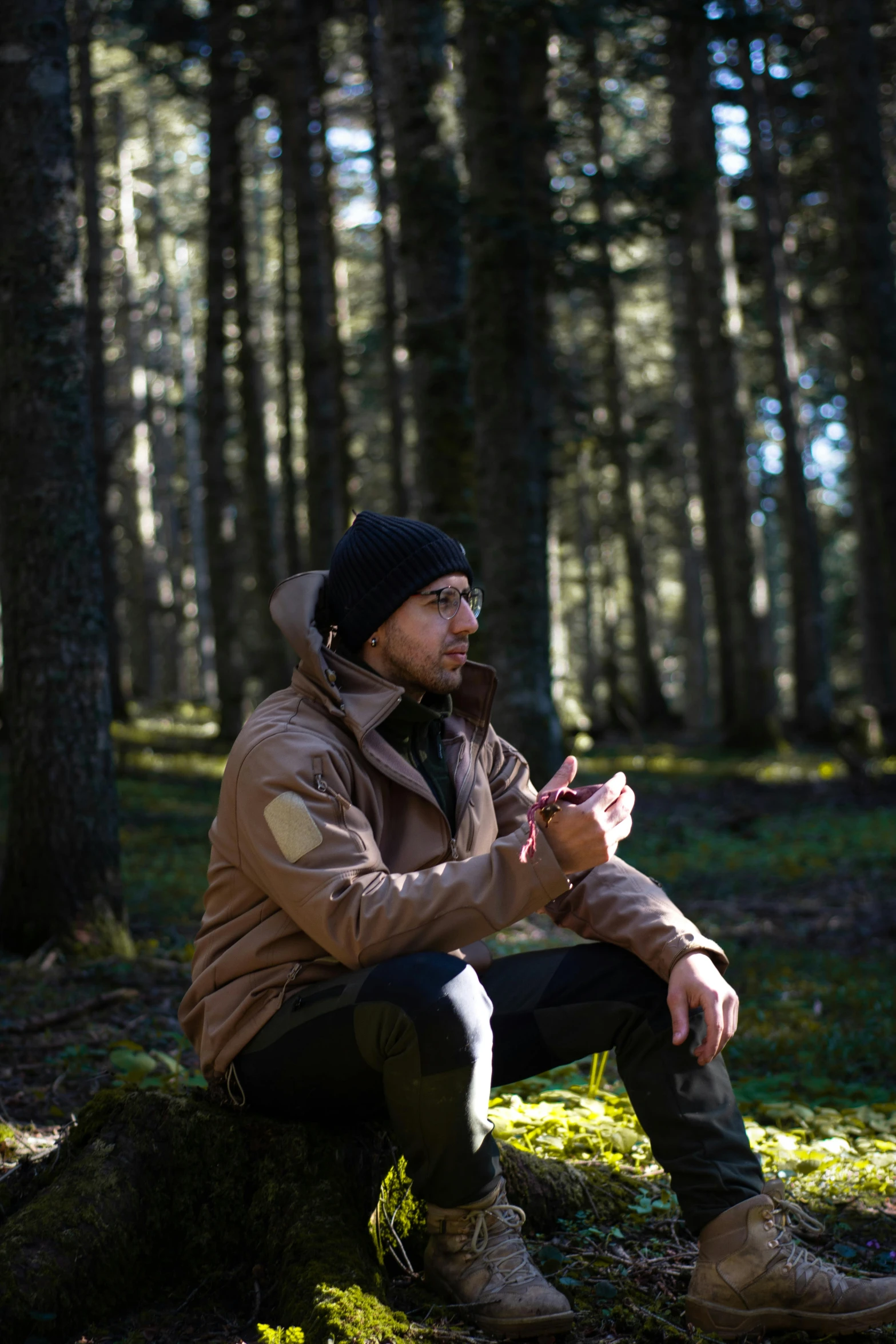 a man sits in the woods wearing his hiking gear