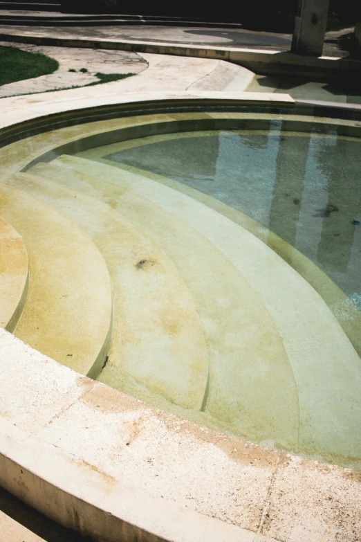 a concrete bench sits near an abstractly designed pool