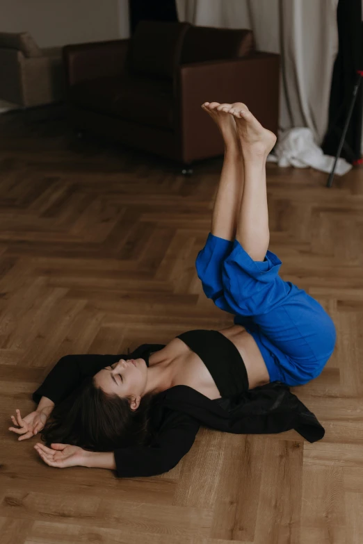 a woman lying on the floor wearing blue top