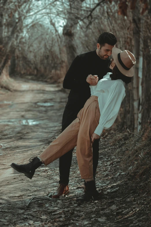 an adult man is holding up a woman on the side of a trail