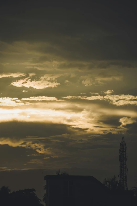 a sunset with a plane in the foreground and a church steeple to the left